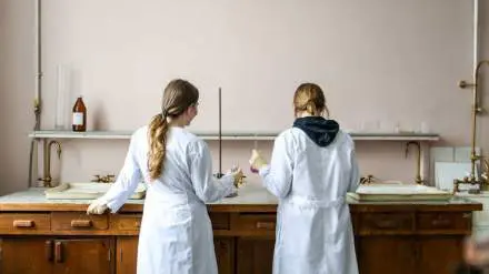 Deux jeunes femmes de dos dans un laboratoire de chimie.