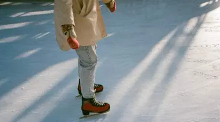 Une fillette sur une patinoire. IMage cadrée sur les jambes et les patins.