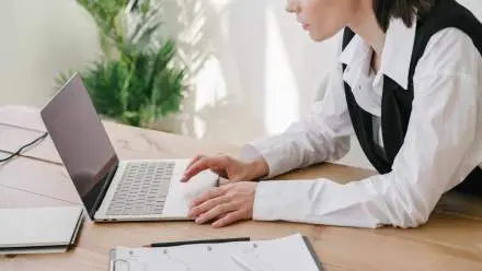 Une femme utilise un ordinateur portable dans un bureau.