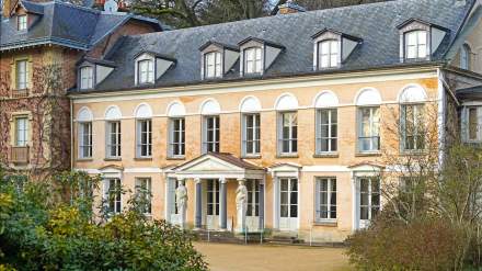 Façade de la maison de Chateaubriand à Châtenay-Malabry, bâtiment historique en briques avec fronton et statues, entouré de végétation